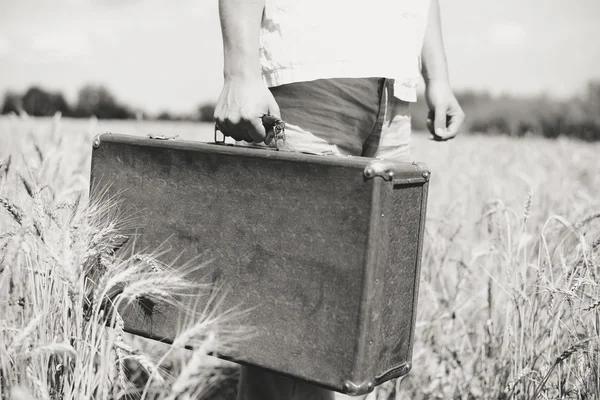 Preto e branco campo imagem de mão segurando mala retro — Fotografia de Stock