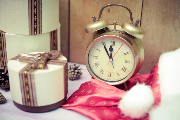 Three round gift boxes with alarm clock and Santa hat — Stock Photo, Image
