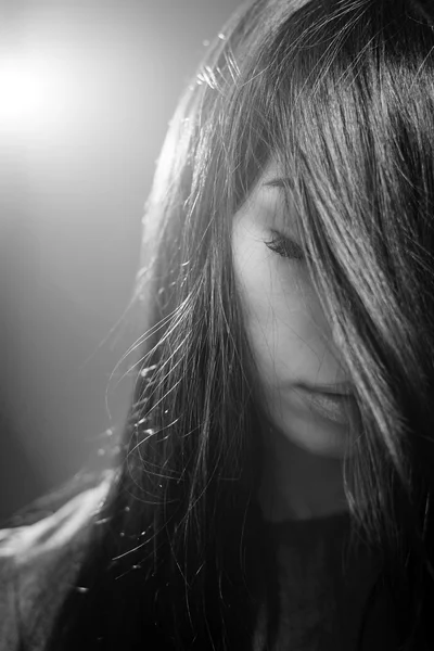 Чорно-біла фотографія мрійливої красивої дівчини, яка тримає очі закритими позує на фоновому копіювальному просторі світла — стокове фото