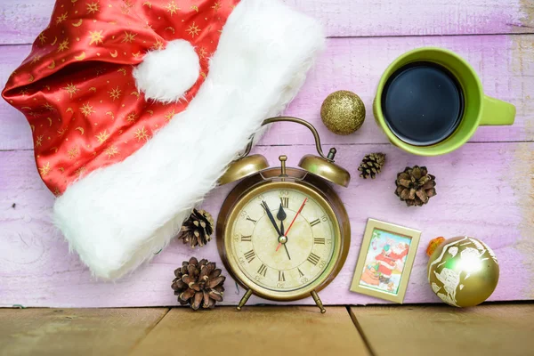 Alarm clock with Christmas ornaments beside Santa hat and coffee — Stock Photo, Image