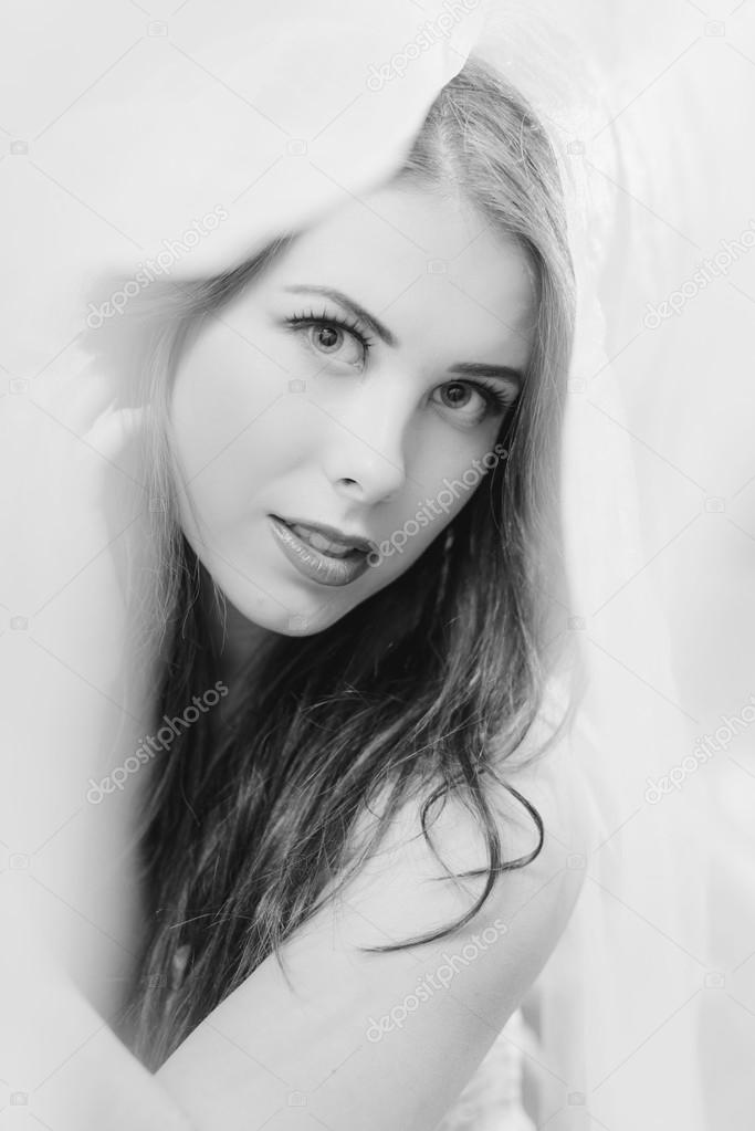 Black and white of beautiful young lady sensually looking at camera, close up portrait