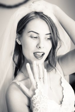 Close up of beautiful sensual young lady in white lingerie showing engagement ring and happy smiling