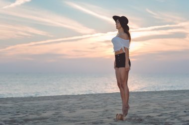Attractive brunette having fun jumping in air on sandy beach