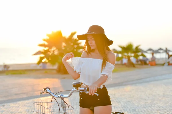 Atraktivní usměvavá dáma baví jezdit na kole podél nábřeží — Stock fotografie