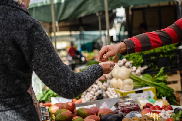 Imagen del mercado con diferentes frutas. Compradores y vendedores mano sobre fondo colorido . — Foto de Stock