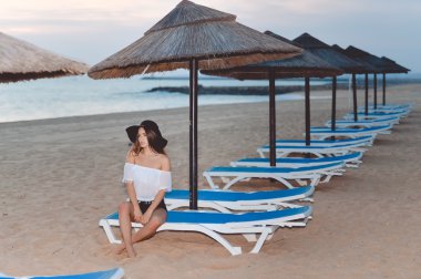 Lounge oturan siyah disket zarif şapkalı çekici hanım