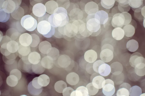 Light blurred background with white bokeh lights on it. Festive holiday theme with copyspace