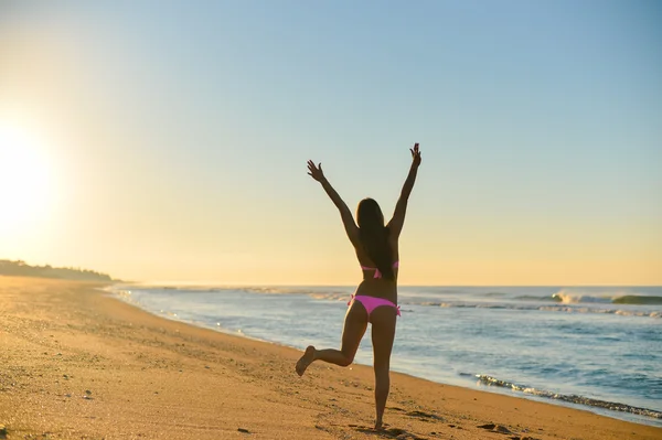 Sexig tjej kör på stranden, i en snygg bikini njuter av sommarlovet — Stockfoto