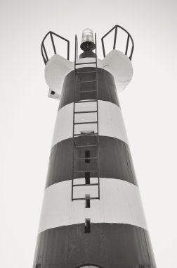 Beautiful lighthouse with bright sun on top on sky background