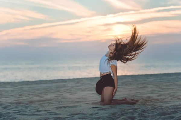 Aufgeregt Brünette Mädchen sitzt auf Sandstrand — Stockfoto