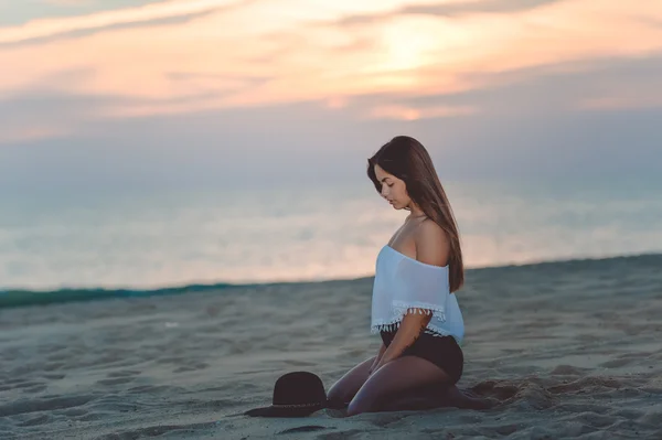 Krásná žena, sedící na písečné pláži — Stock fotografie