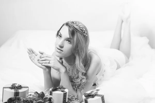 Hermosa joven con regalos en la cama. Retrato blanco negro —  Fotos de Stock