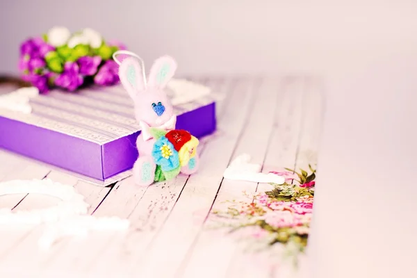 Handmade rabbit, gift box and decorations on wooden table background — Stock Photo, Image