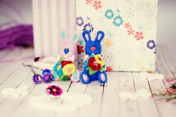 Bunny rabbits, gift boxes and artistic decorations on wooden table background — Stock Photo, Image