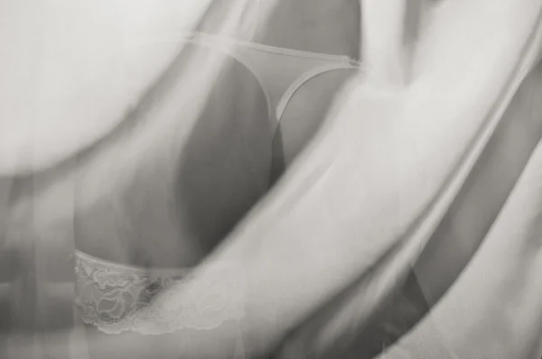 Closeup on sexy buttocks hiding behind tulle curtain — Stock Photo, Image