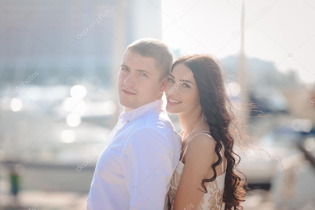 Happy loving couple on sunny marina outdoors background