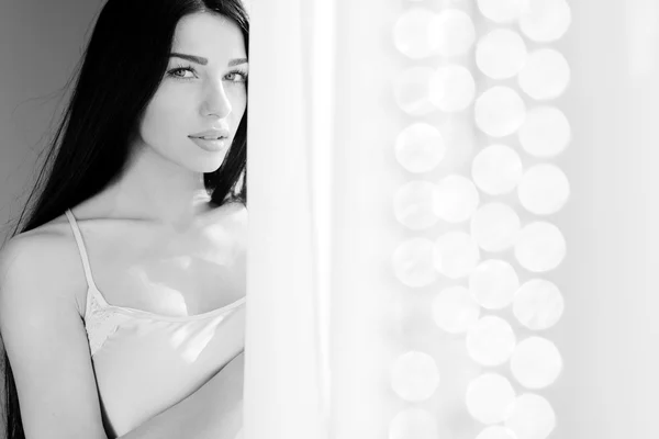 Чорно-біла фотографія привабливої молодої леді над вікном боке — стокове фото