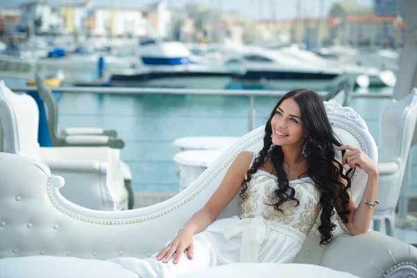 Vrolijke vrouw in elegante jurk op zonnige dag in marina — Stockfoto