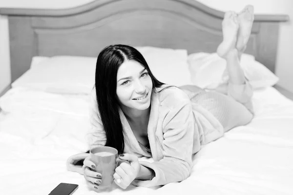 Preto e branco fotografia de beber café ou chá atraente feliz sorrindo jovem senhora — Fotografia de Stock