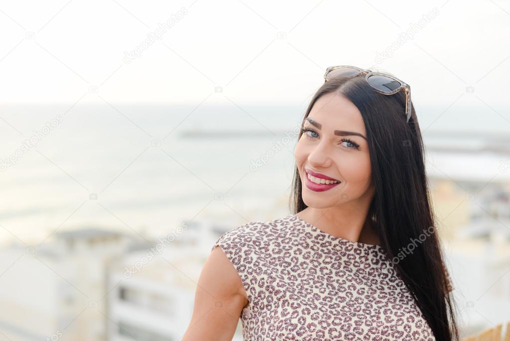 Beautiful girl looking over ocean and sky background