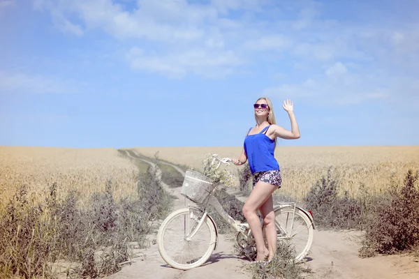 Pretty woman with bike on countryside landscape blue sky background outdoors — Stock Photo, Image