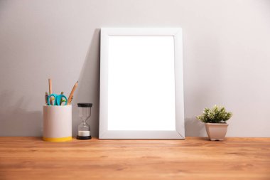 Beyaz, boş ahşap çerçeve. Masanın üzerinde çiçekler var. .