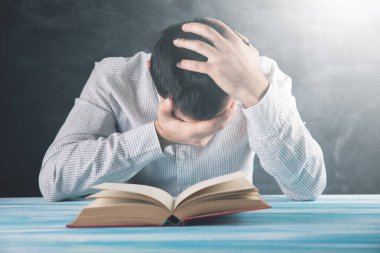 Genç adam kitap okumaktan yoruldu.