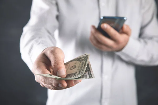 a man holding a phone and money in his hand .