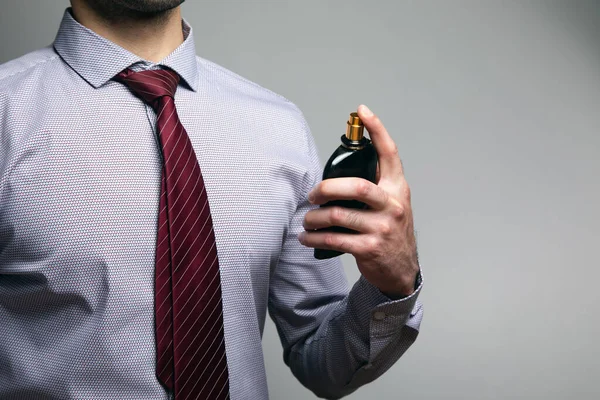 Mann Versprüht Parfüm Auf Grauem Hintergrund — Stockfoto