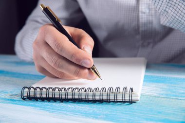 Not defterine notlar yazar. .