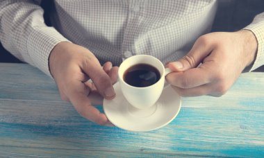 Elinde kahve tutan bir adam. .