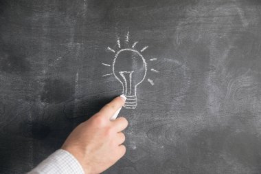 Tahtaya tebeşirle bir lamba çizer .