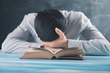 Genç adam kitap okumaktan yoruldu.
