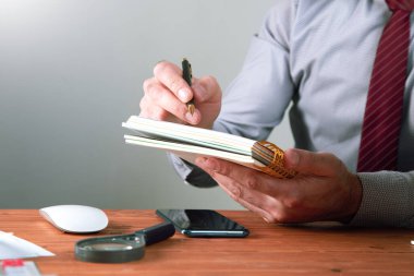 Not defterine notlar yazar. .