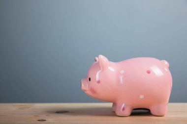 Domuz kumbarası ahşap bir masada.