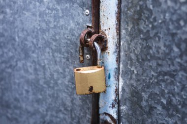 Sokakta paslı bir kapının kilidini aç.