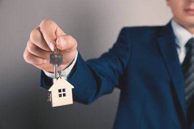 Elinde anahtarlar olan genç adam, evi süsledi.