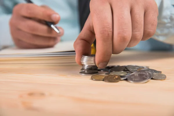 a man makes calculations and writes in a notebook