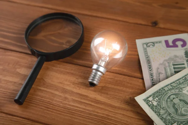 light bulb and money with magnifying glass search business ideas