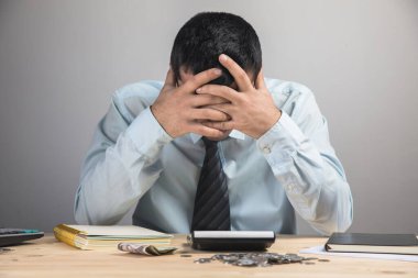 Kafasını bir masaüstünde tutan bir adam.