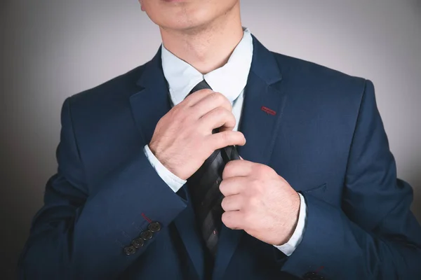 young businessman straightens his tie.