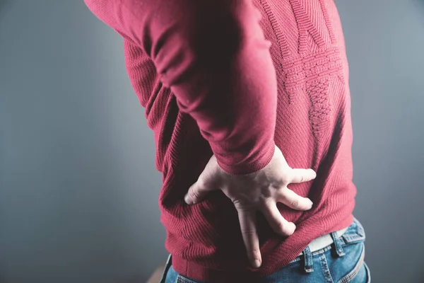 Jong Guy Holding Een Nier Pijn Een Grijze Achtergrond — Stockfoto