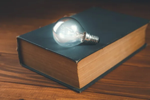 Glühbirne Und Buch Auf Dem Tisch Neue Ideen — Stockfoto