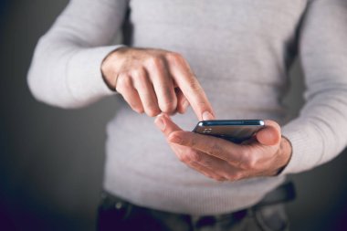 Adam telefon ekranına bastırıyor.