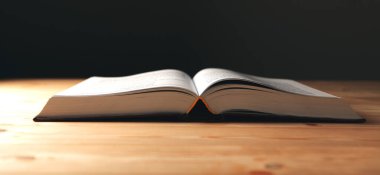 Tahta bir masanın üzerinde açık bir kitap