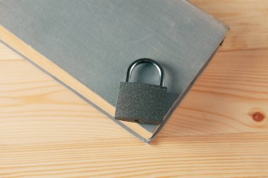 Kitap ve kilit ahşap bir masa üzerinde, gizli bilgi