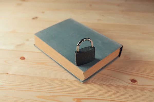 book and lock on a wooden table, hidden knowledge