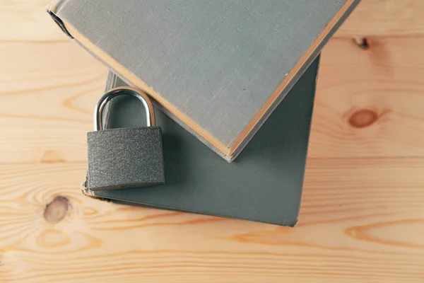 book and lock on a wooden table, hidden knowledge