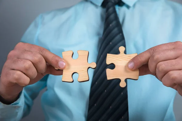 a man connects two puzzle pieces