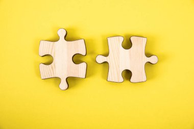 Sarı arka planda bir yapbozun iki parçası